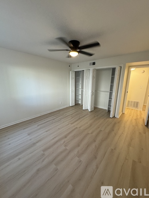 A room with a ceiling fan and light, and a door with a window.