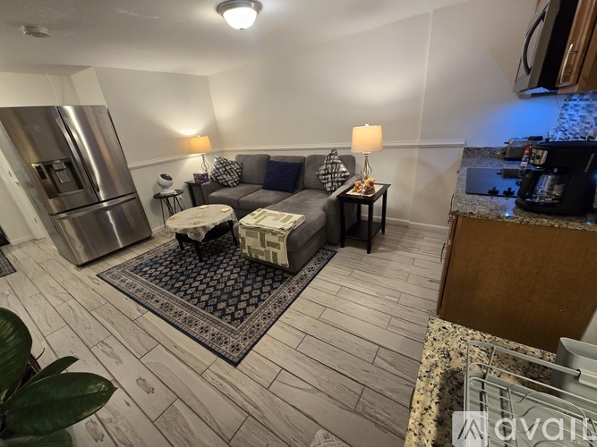 A kitchen with a refrigerator, a couch, and a coffee table.