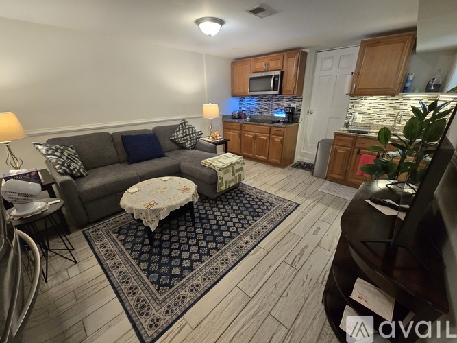 A living room with a couch, a coffee table, and a television.