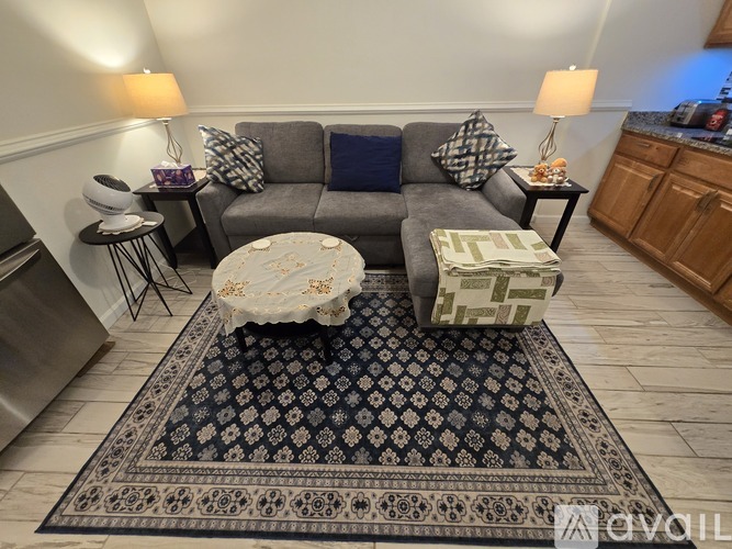 A living room with a grey couch and a coffee table with flowers on it.