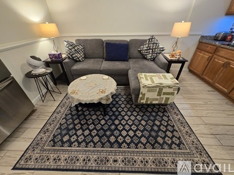 A living room with a grey couch and a coffee table with flowers on it.