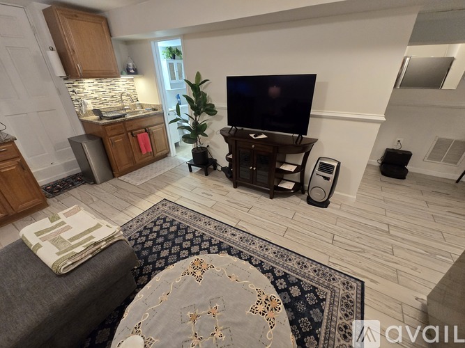 A bedroom with a bed, nightstand, and a round mirror on the wall.