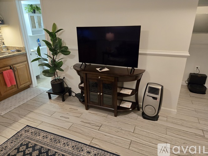 A living room with a grey couch, a patterned rug, and two lamps.