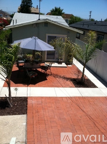A patio with a table and chairs under an umbrella.