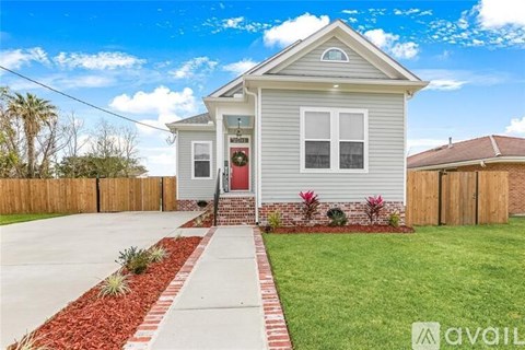 A house with a red door and a red brick pathway leading to it.
