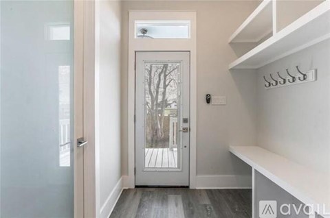 A white door with a glass window is in the middle of a hallway.