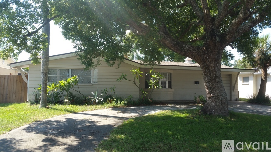 A house with a tree in front of it is for sale.