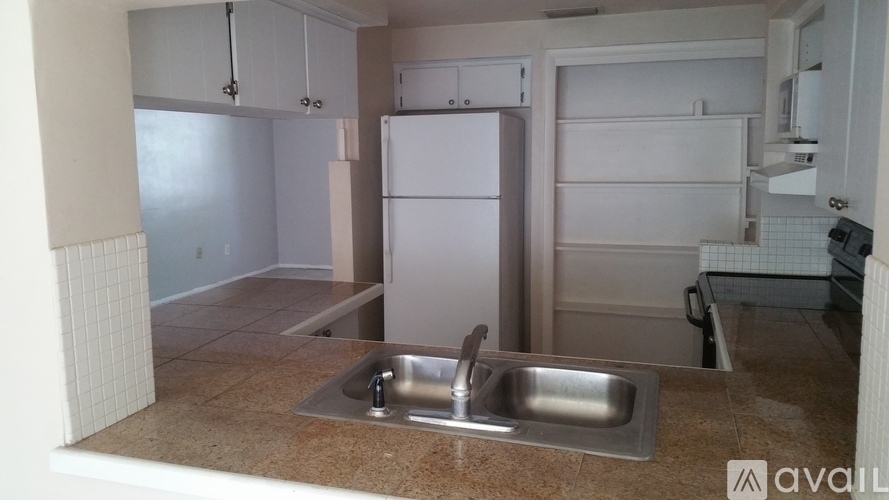 A kitchen with a sink and a refrigerator.