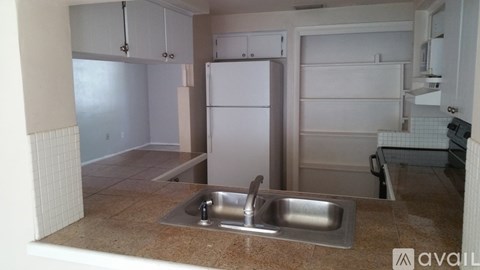A kitchen with a sink and a refrigerator.