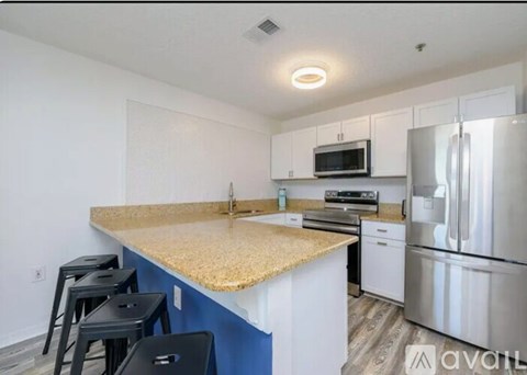 A kitchen with a granite countertop and stainless steel appliances.