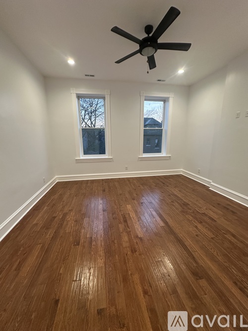 A room with wooden flooring and a ceiling fan.
