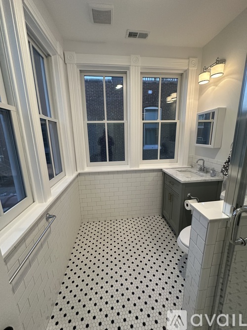 A bathroom with a black and white tiled floor.