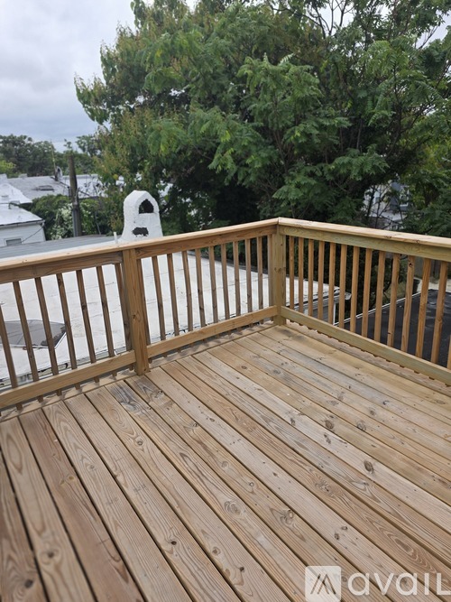A wooden deck with a railing and a white object in the background.