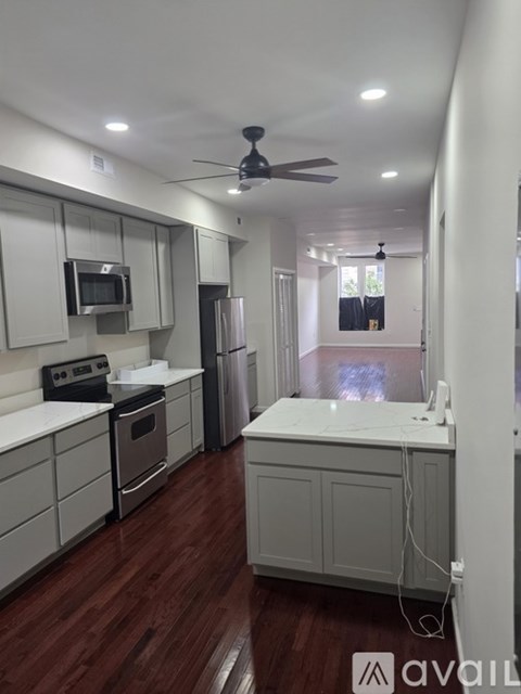 A kitchen with white cabinets and a wooden floor.
