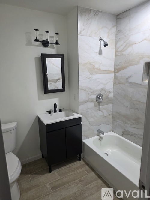 A bathroom with a marble wall and a white sink.