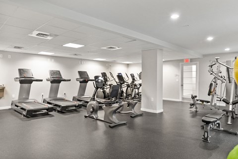 A gym with treadmills, exercise bikes, and other equipment.