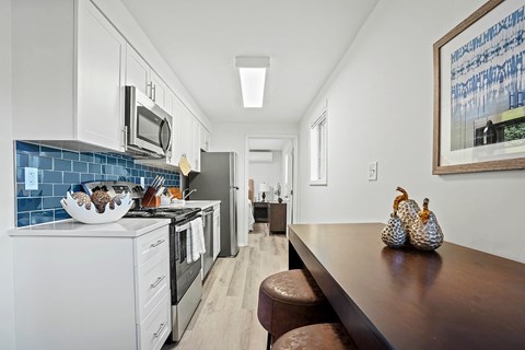 A kitchen with a white oven and a blue tile backsplash.