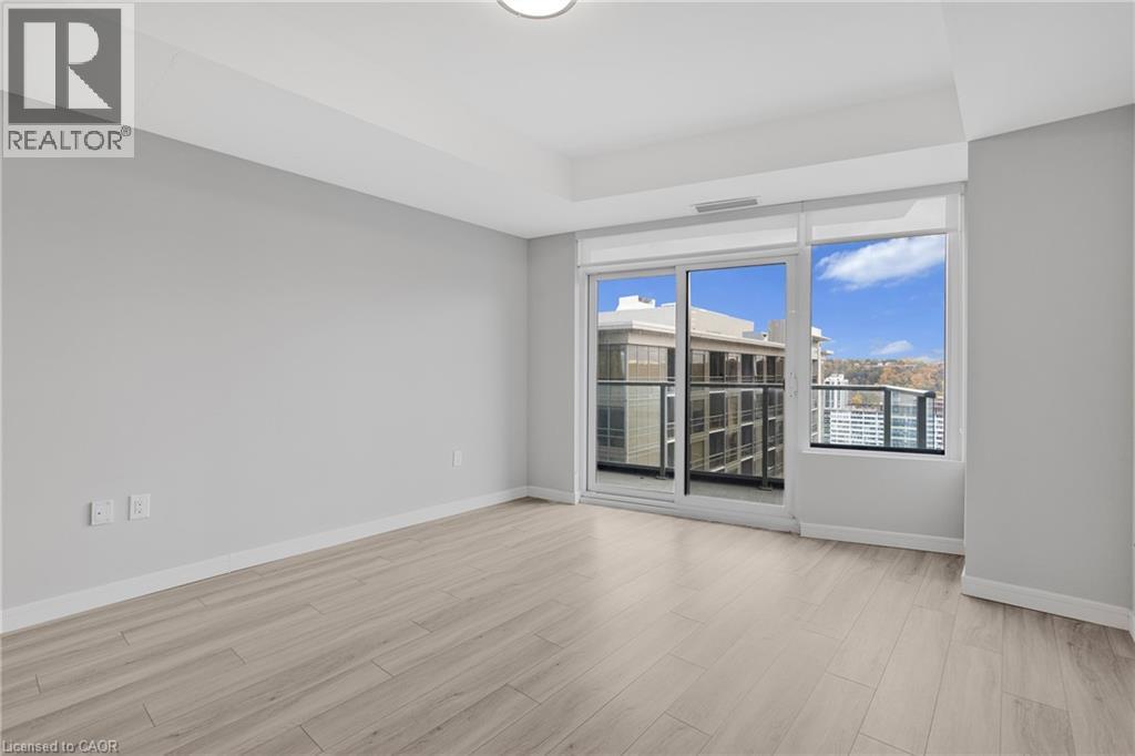 A spacious room with a sliding glass door leading to a balcony.