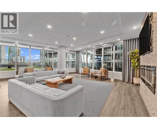A spacious living room with a large grey sofa and a wooden coffee table.