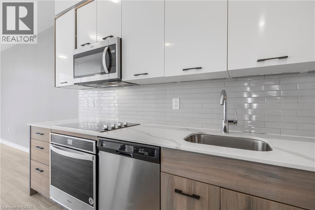 A modern kitchen with a stainless steel oven and microwave above the counter.