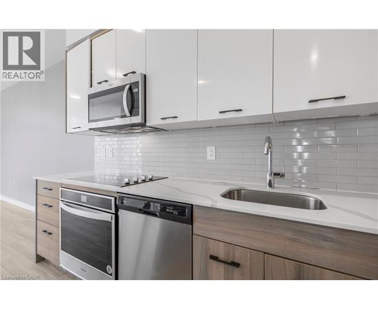 A modern kitchen with a stainless steel oven and microwave above the counter.