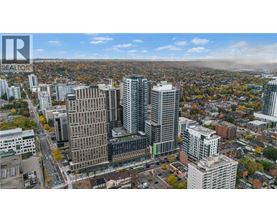 A cityscape with a mix of modern and older buildings, with a clear sky and some clouds.