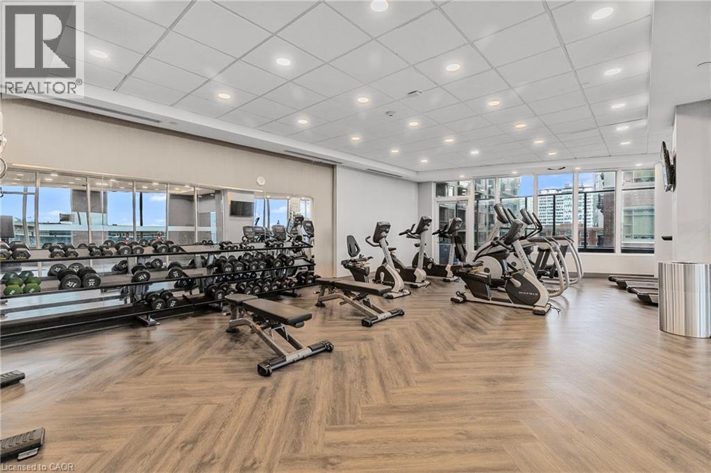 A gym with a variety of exercise equipment including treadmills, stationary bikes, and dumbbells.