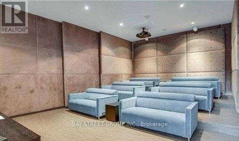 A living room with a row of grey couches and a wooden floor.