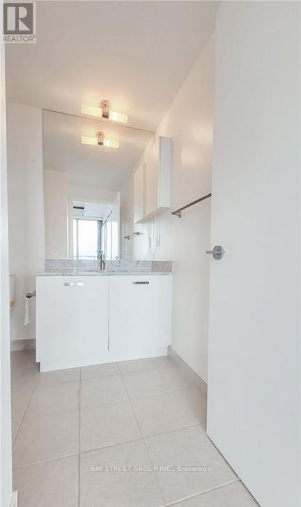 A white kitchen with a sink and cabinets.
