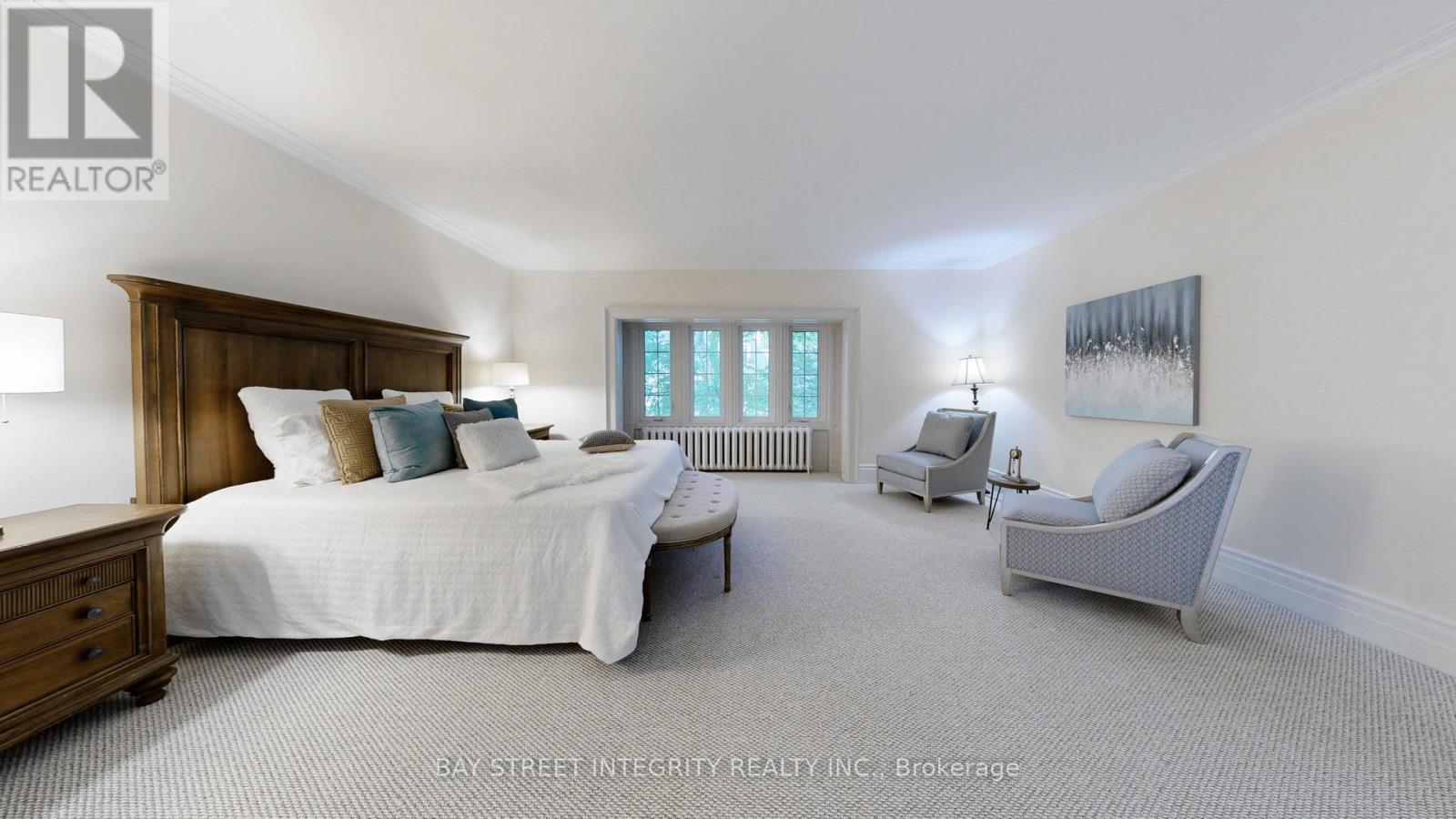 A bedroom with a large bed and a chair.