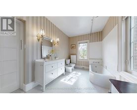 A well-lit, spacious bathroom with a white vanity and a bathtub.