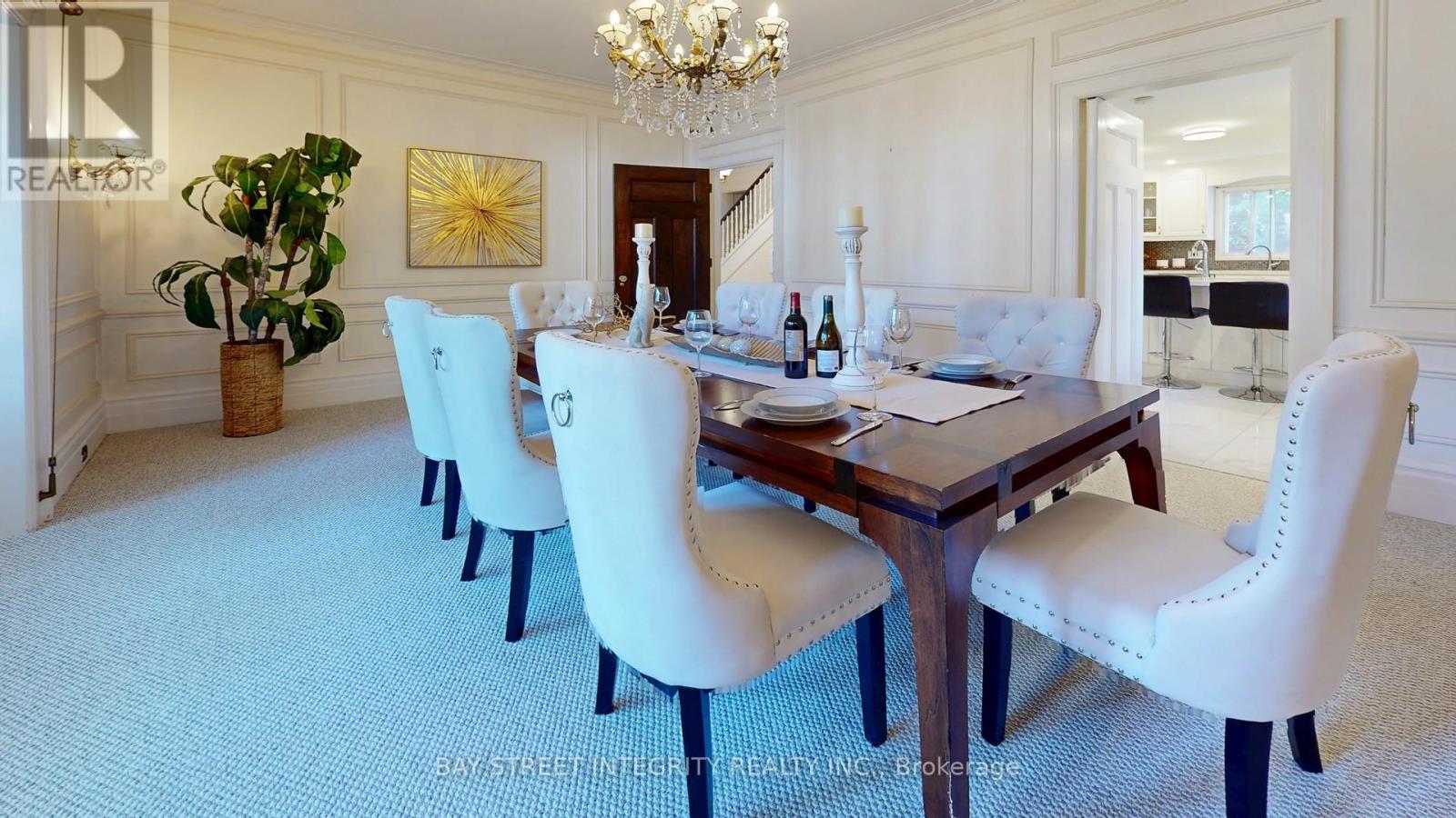 A dining room with a large table and chairs.