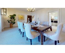 A dining room with a large table and chairs.