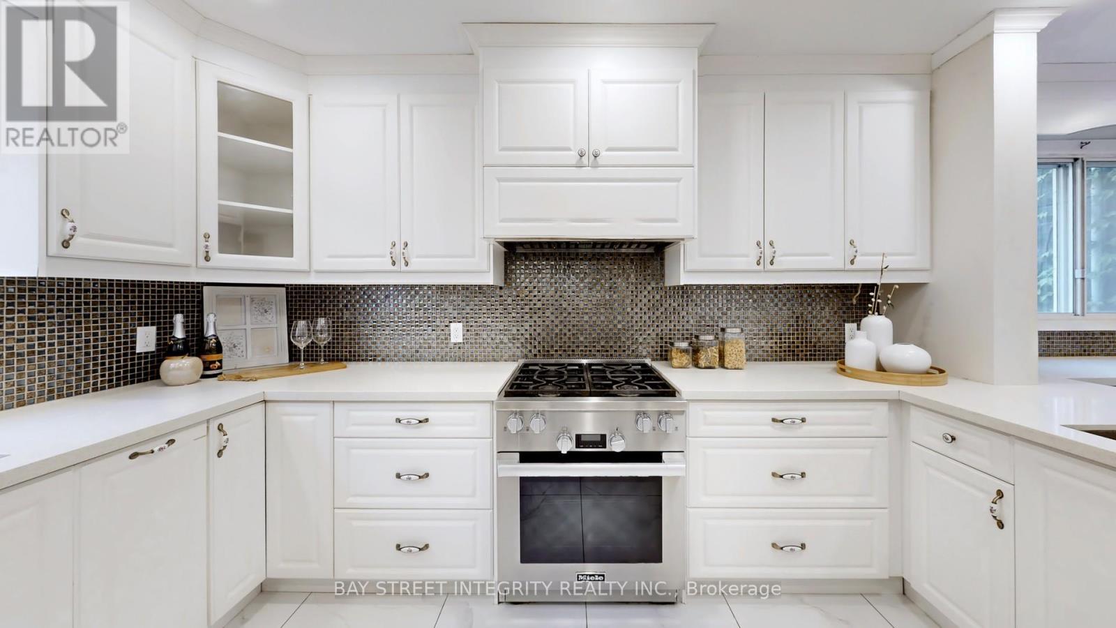 A kitchen with white cabinets and a black stove top.
