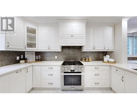A kitchen with white cabinets and a black stove top.