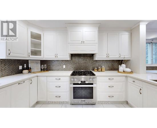 A kitchen with white cabinets and a black stove top.
