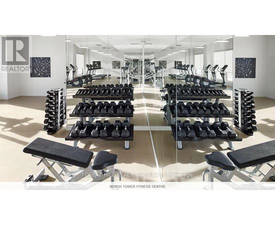 A gym with a variety of equipment including dumbbells and benches.