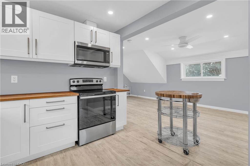 A modern kitchen with white cabinets and a wooden countertop.