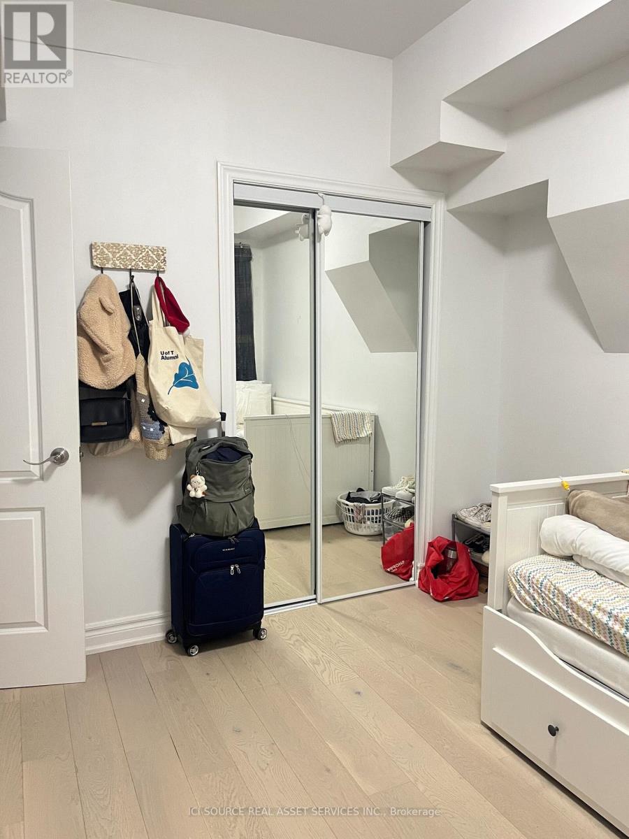 A bedroom with a white bed and a mirror on the wall.