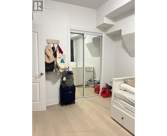 A bedroom with a white bed and a mirror on the wall.