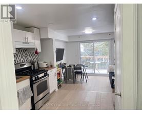 A kitchen with a stove top oven and a dining table with chairs.