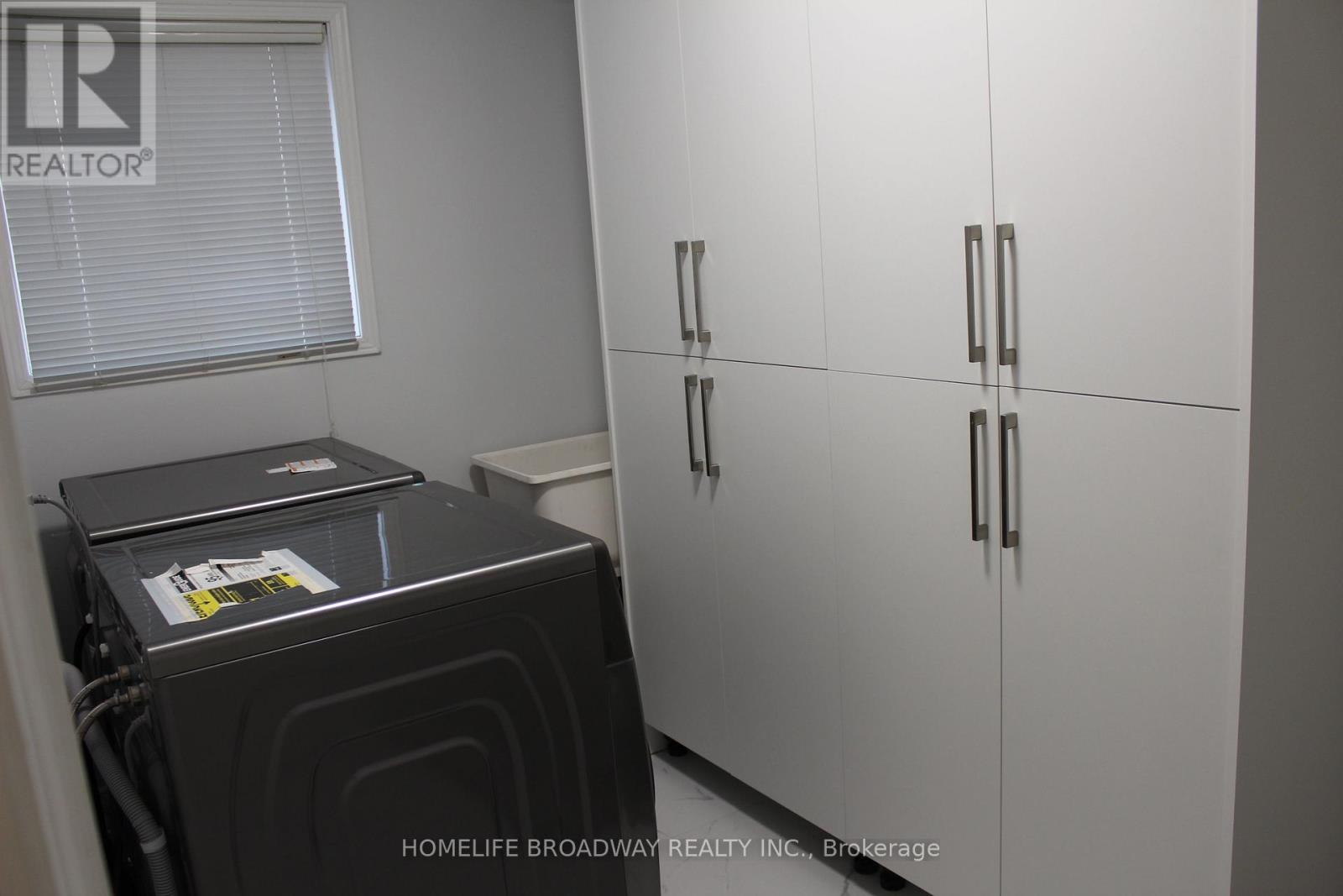 A black stove is in a kitchen with white cabinets.