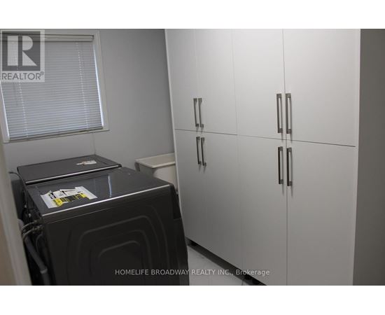 A black stove is in a kitchen with white cabinets.