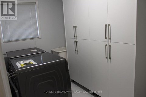 A black stove is in a kitchen with white cabinets.