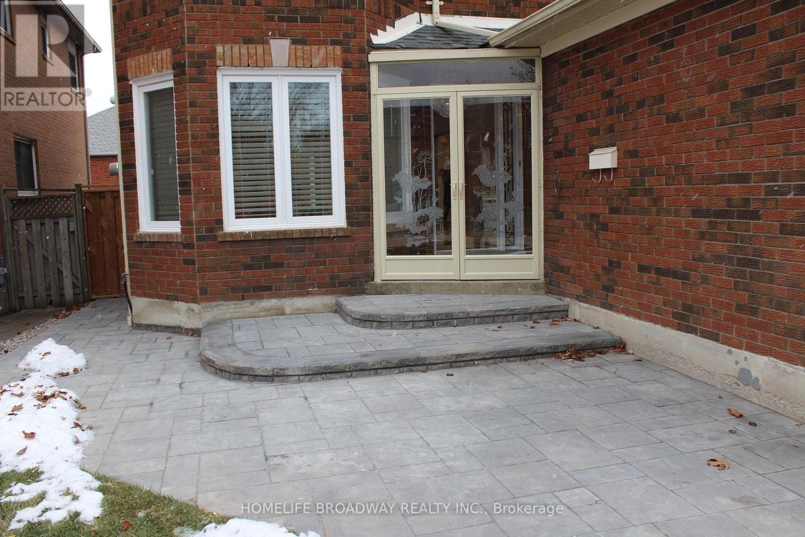 A brick house with a glass door and a small porch.