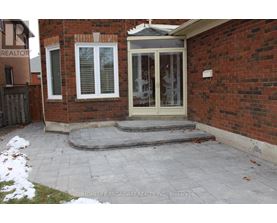 A brick house with a glass door and a small porch.
