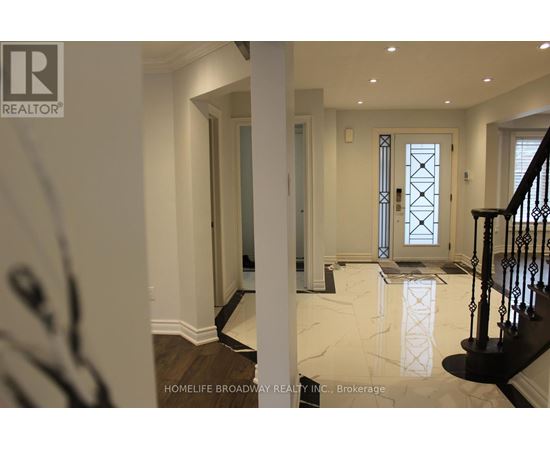 A hallway with a marble floor and a staircase with a black railing.
