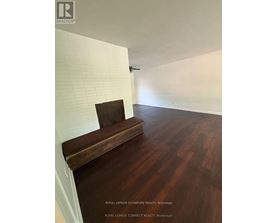 A room with a wooden bench and a white wall.