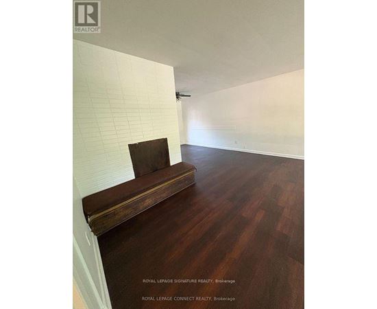A room with a wooden bench and a white wall.