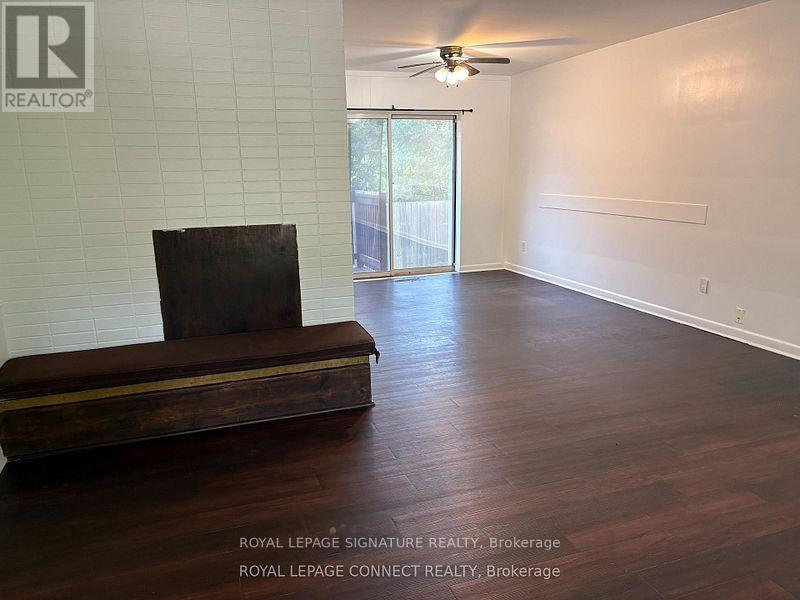 A room with a wooden floor and a brown couch.